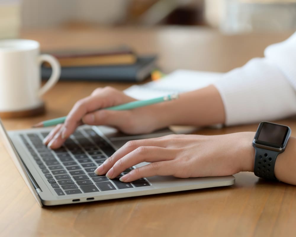 Hands typing on a laptop